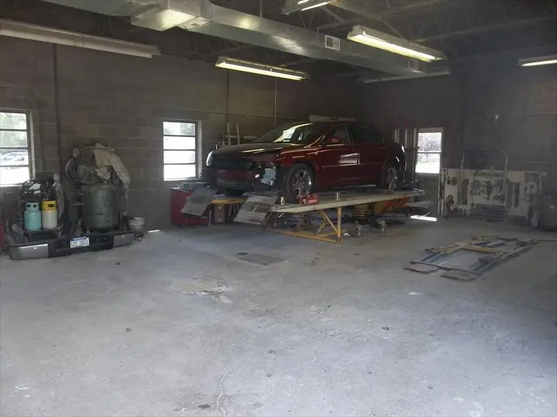 Red sedan on the frame straightening rack in the Lochmoor repair bay