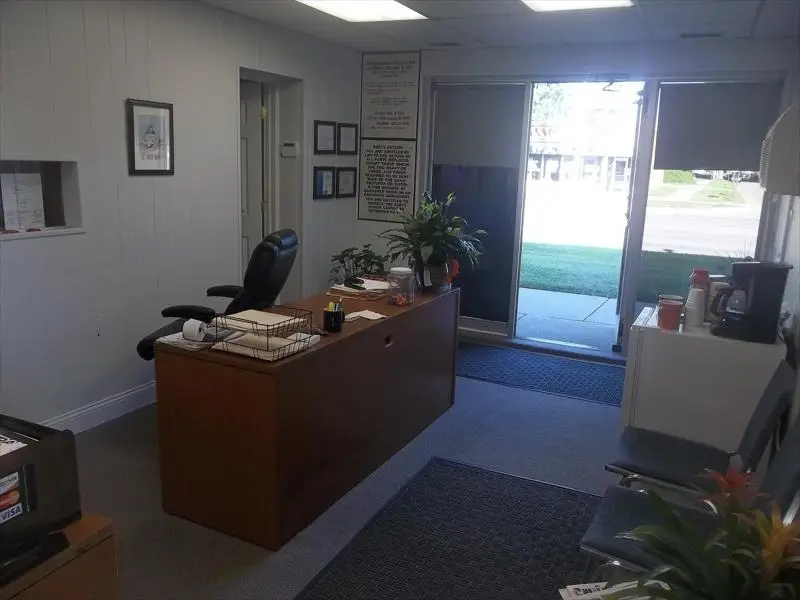 Front office with a desk, plants, and the front door open to Greater Mack Ave