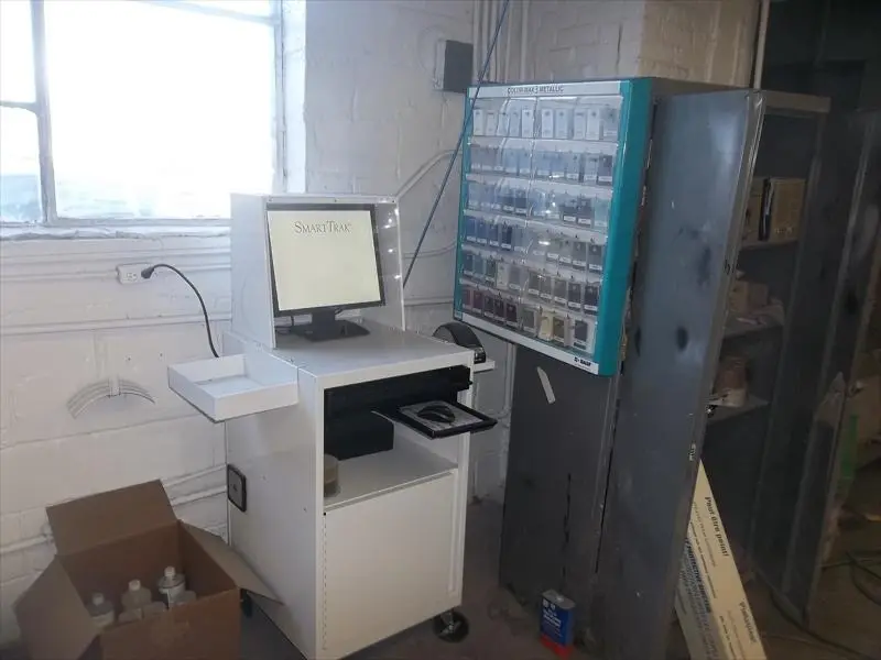 Paint color matching computer next to a rack of metallic color chips